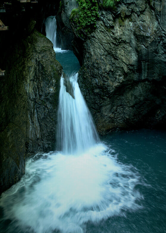 Wasserfälle mit türkisblauem Wasser in Felsenschlucht.