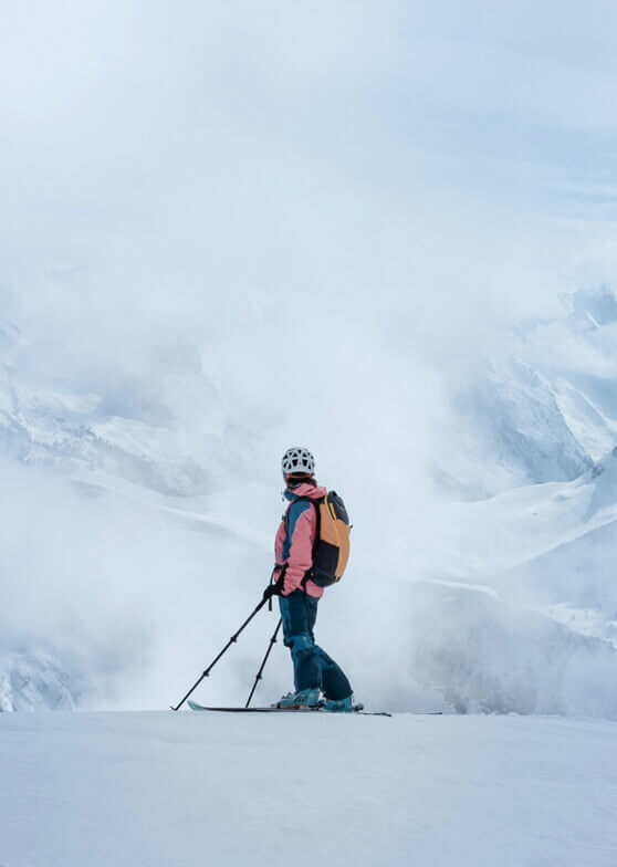 Skifahrer auf Schnee blickt auf neblige Berge.