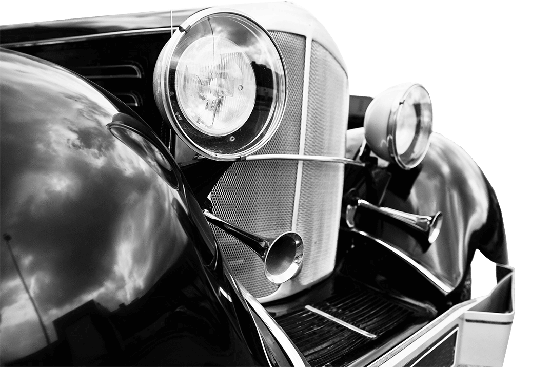 Schwarzweißfoto: Oldtimer-Front mit Scheinwerfern, Kühlergrill.