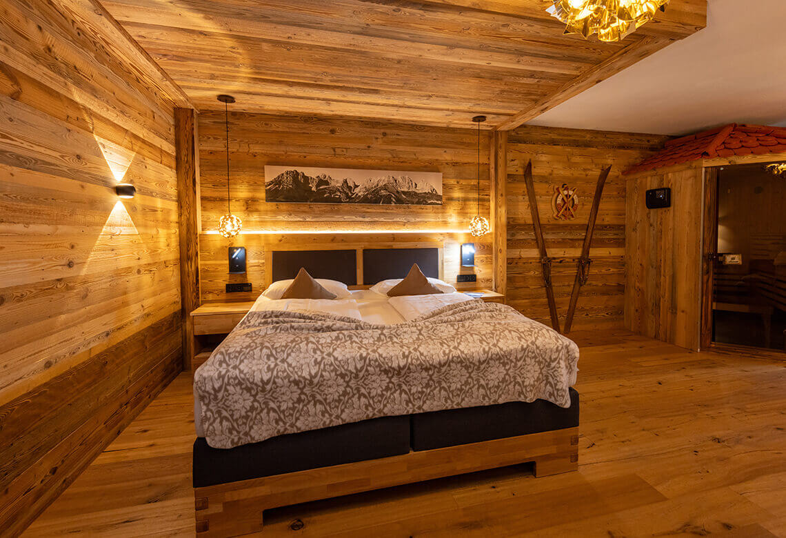 Schlafzimmer aus Holz mit Doppelbett und Sauna.