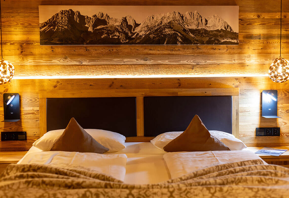 Schlafzimmer mit Doppelbett, Holzwänden, Bergbild.