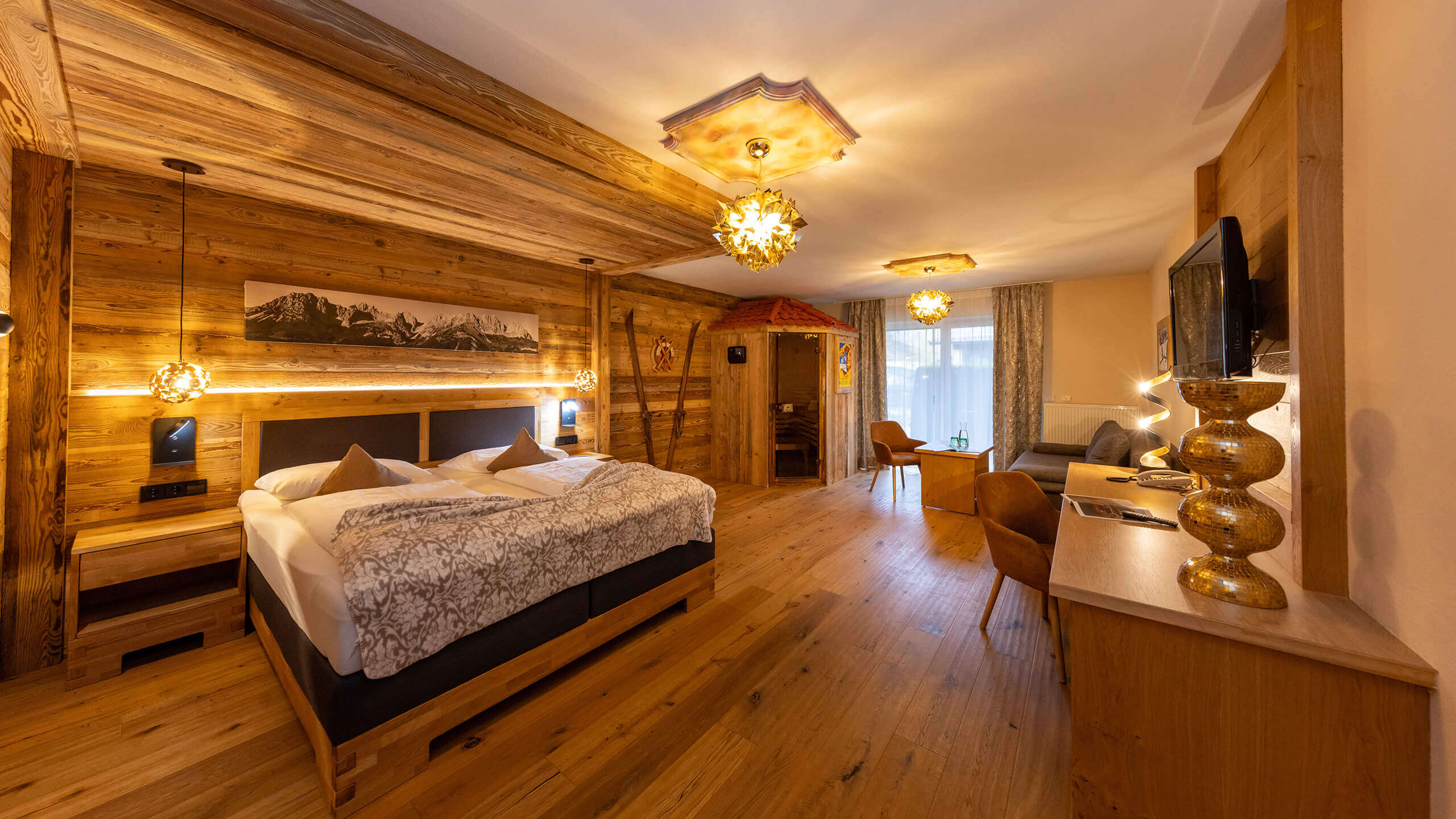 Holzgetäfeltes Hotelzimmer mit Bett, Sauna und Sitzbereich.