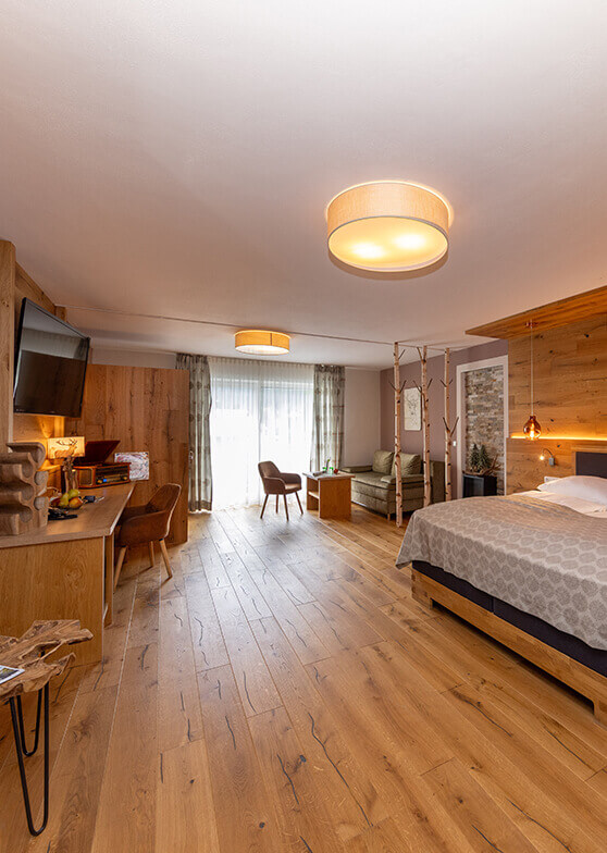 Hotelzimmer mit Holzboden, Bett und Sitzbereich.