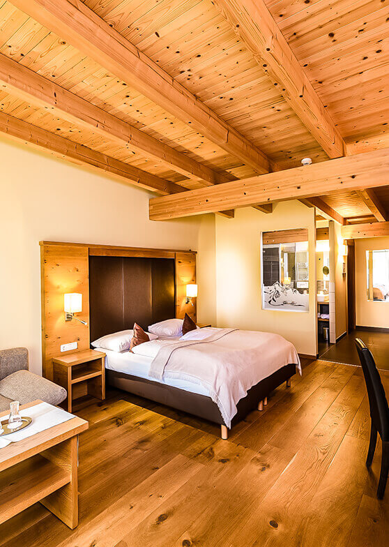 Ein Schlafzimmer mit Doppelbett, Holzboden und Holzdecke.