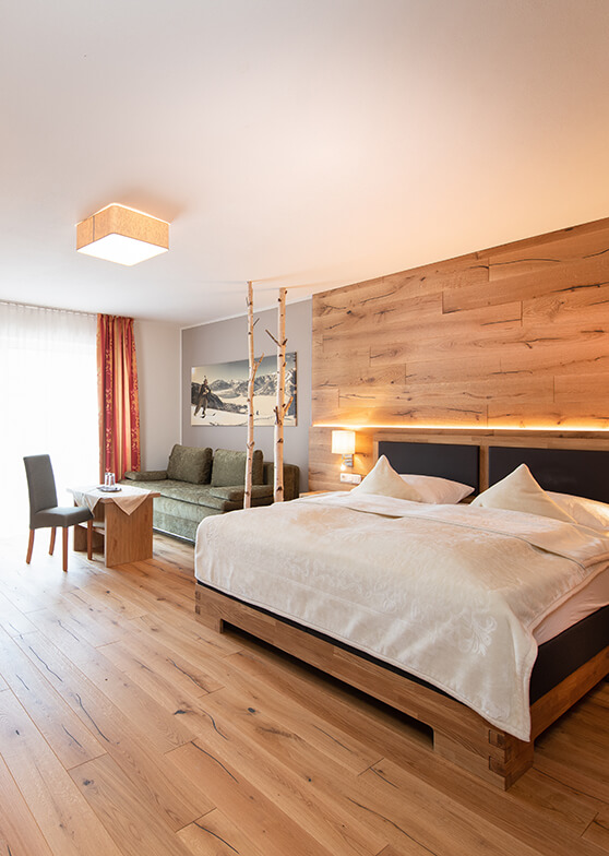 Modernes Schlafzimmer mit Bett, Holzwand und Holzboden.