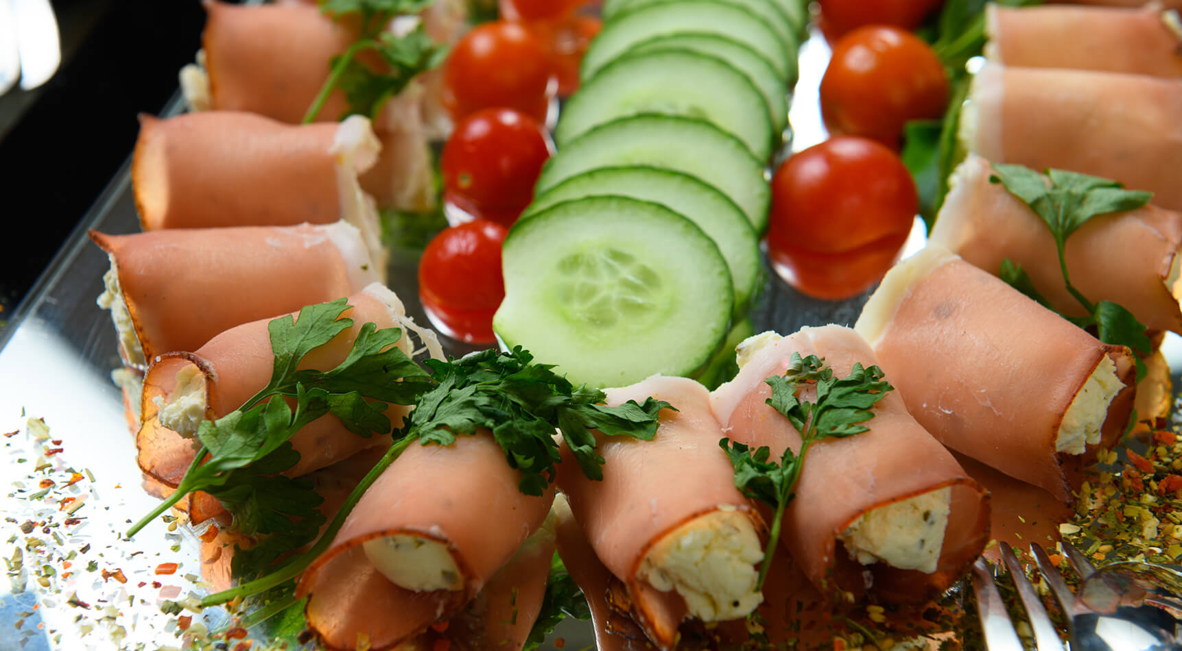 Schinkenröllchen, Gurkenscheiben, Tomaten und Petersilie.