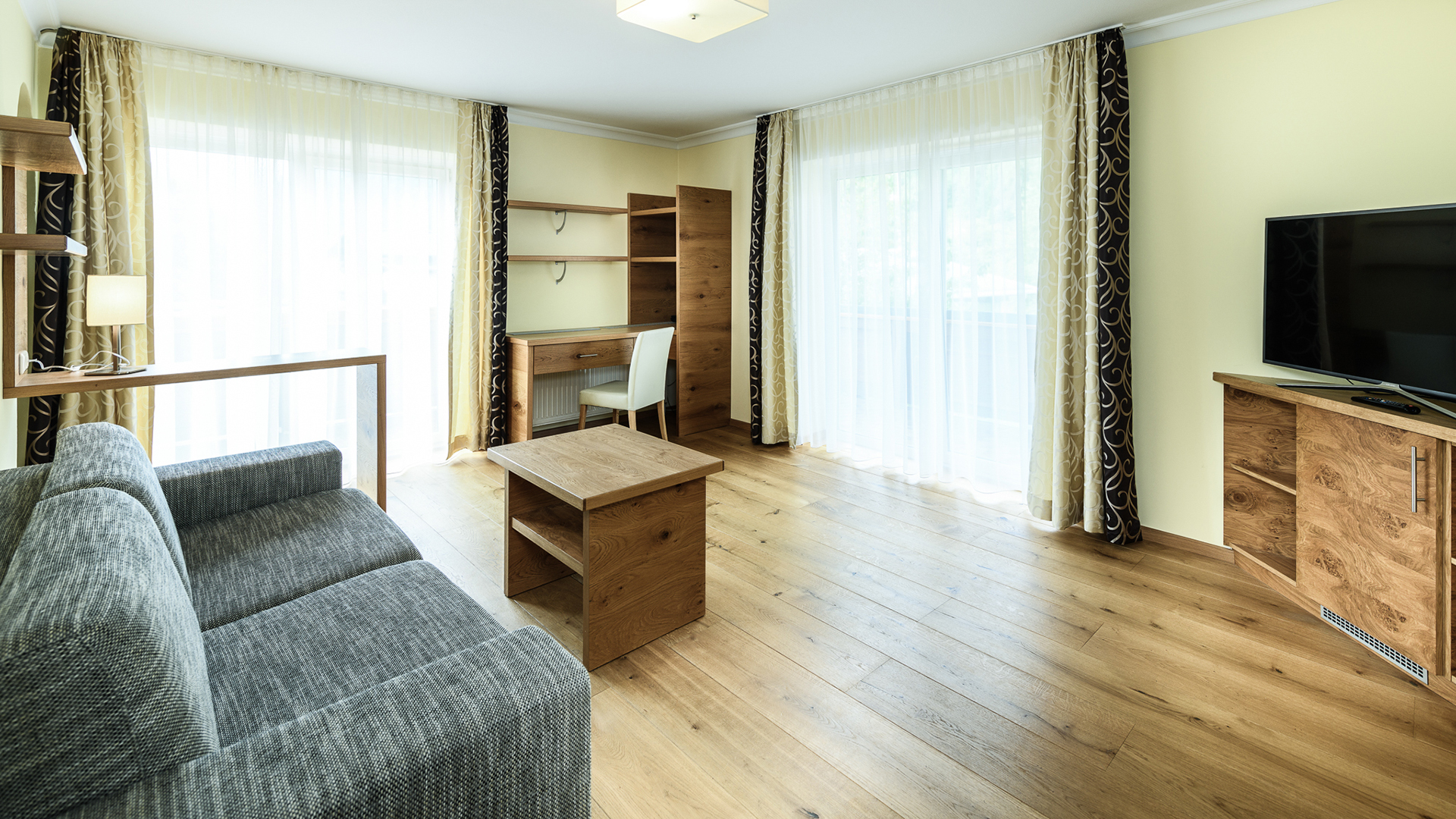 Couch, Schreibtisch, TV, Fenster/Tür zu Balkon