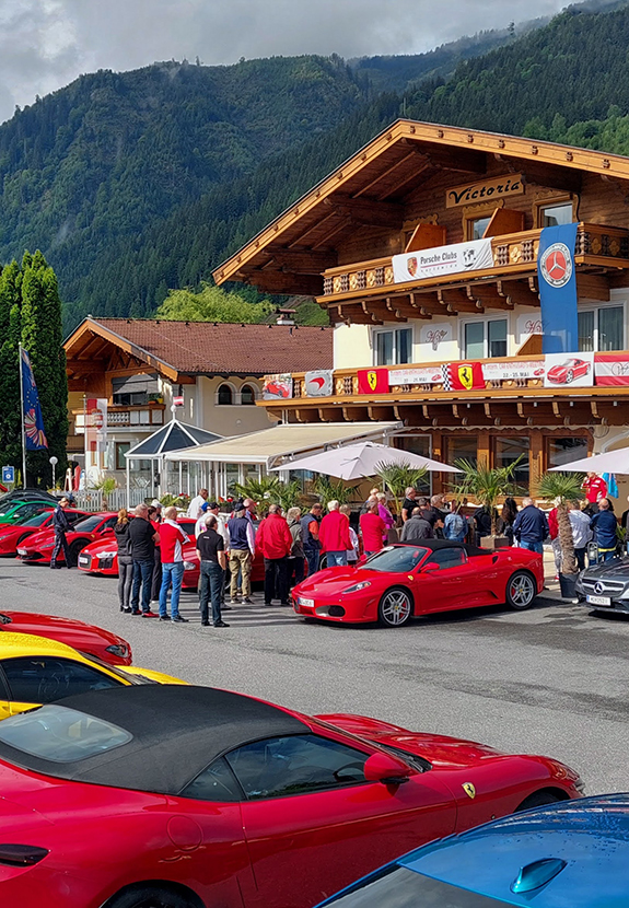 Rote Sportwagen, Menschen vor Hotel Victoria und Bergen.