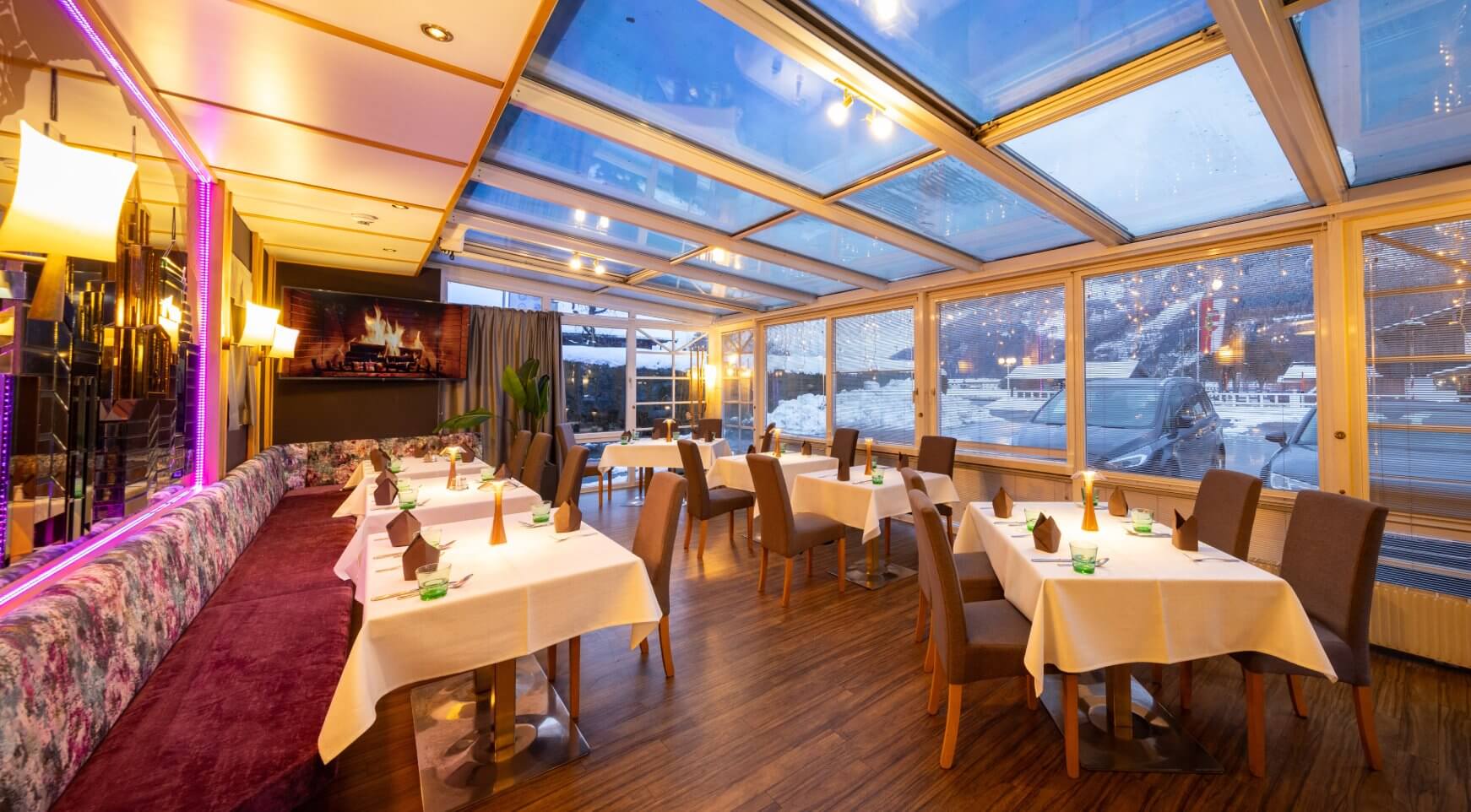 Modernes Restaurant mit Glasdach, Tischen, Winterblick.