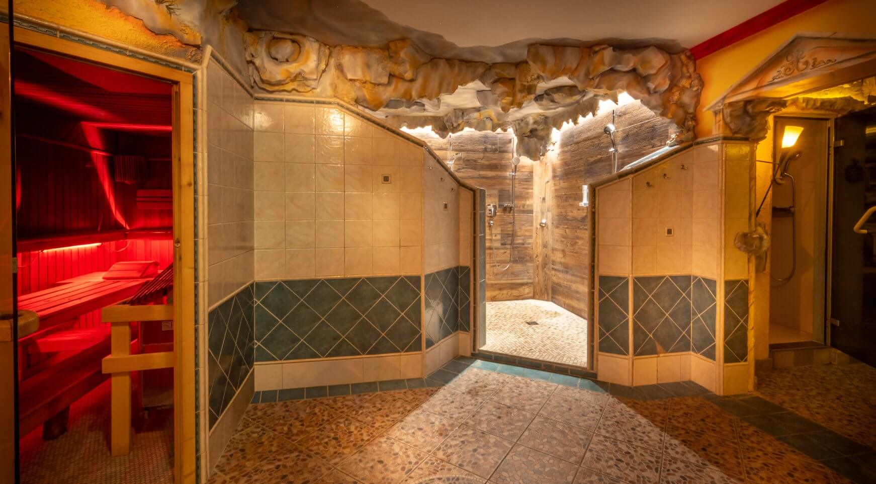 Rote Sauna, Duschbereich mit Holz und Felsen-Decke.